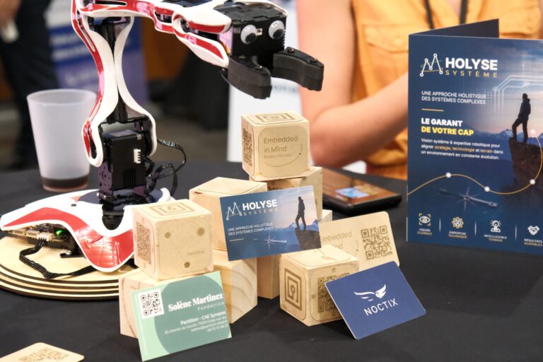 A LynxMotion 4-DOF robotic arm surrounded by company logos for a technical demonstration